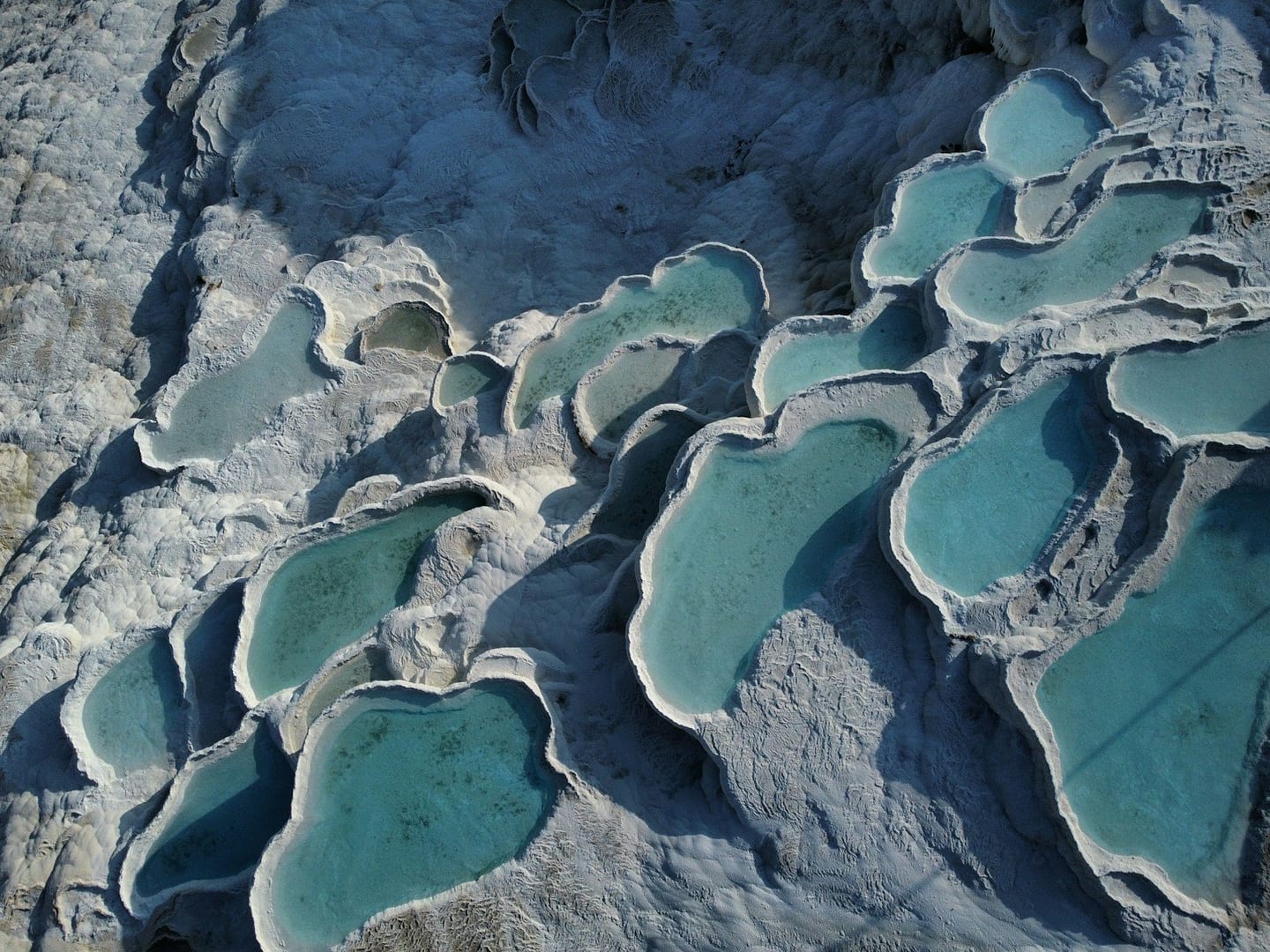 An aerial view of a mountain range with blue water